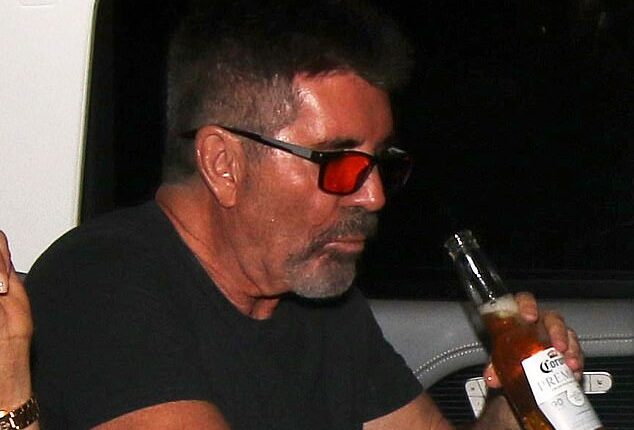 Simon Cowell was spotted swigging a beer with his partner Lauren Silverman in the back of a taxi as they headed home after the first Britain's Got Talent semi-final on Monday
