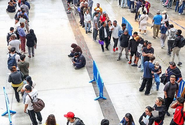 People queue to receive documentation in Hospitalet de Llobregat, near Barcelona, Spain