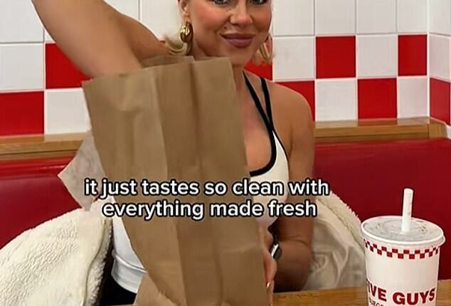 It was once the trendiest dining out option available - but now burger joints are slowly fading for Britain's streets (pictured: Influencer Gabby Allen at Five Guys)