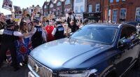 A convoy of cars carrying Prime Minister Sir Keir Starmer drives past protesters in Golders Green today. He was booed amid chants of 'traitor'