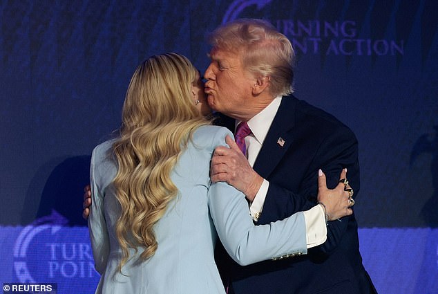President Donald Trump (right) gives Erika Kirk (left) a hug and a kiss as he arrives Friday at Dream City Church in Phoenix, Arizona, for a Turning Point USA 'Build the Red Wall' event