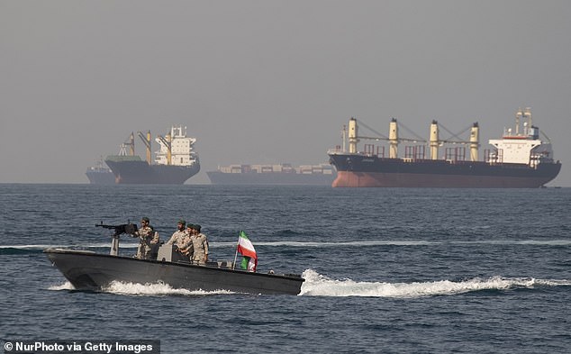 The paramilitary IRGC maintains a separate fleet built for speed and flexibility to control the passage (Pictured: Iranian Navy soldiers on an armed speed boat in Persian Gulf near the Strait of Hormuz)