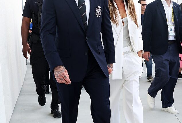 Victoria Beckham looked effortlessly chic in a white suit as she walks hand in hand with husband David to the ribbon-cutting ceremony for his team's new stadium