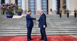 Trump walked over to Xi, who was waiting by the steps, and the pair shook hands, with Trump warmly patting the Chinese leader's hand as they exchanged a few words