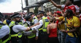 Rowdy Arsenal fans in confrontation with police officers, as one supporter puts his middle fingers up to them