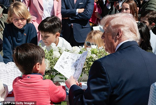 President Donald Trump is photographed as he tells a little boy at Monday's White House Easter Egg Roll how former President Joe Biden used an autopen to sign things