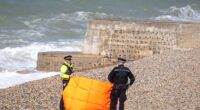Police stand on the beach at Black Rock near Brighton Marina where the bodies of three women were pulled from the water