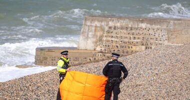 Police stand on the beach at Black Rock near Brighton Marina where the bodies of three women were pulled from the water
