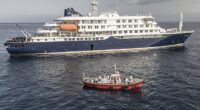 An ambulance boat carrying crew members wearing hazmat suits as they approach MV Hondius, while stationary off the port of Praia, the capital of Cape Verde, on May 5, 2026
