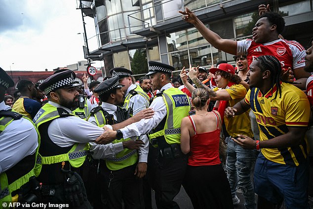 Rowdy Arsenal fans in confrontation with police officers, as one supporter puts his middle fingers up to them