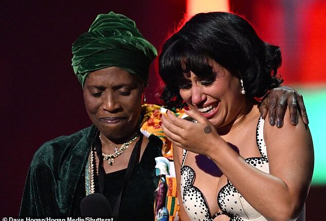Tears of joy: Raye is comforted by her grandmother on stage as she collects her sixth gong