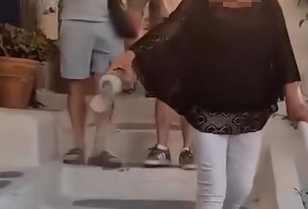 Footage shared to social media showed the woman carrying a clear plastic container filled with what appears to be ash through the picturesque streets of Oia