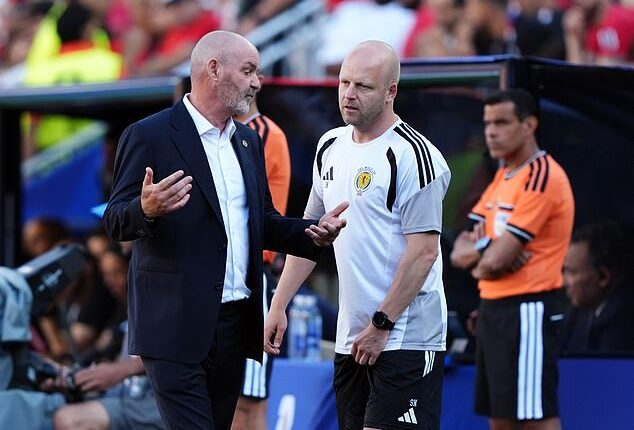 Head coach Steve Clarke consults assistant Steven Naismith during the Morocco match