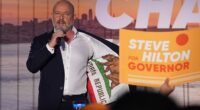 Republican gubernatorial hopeful Steve Hilton shows off his jacket that has a California and USA flag stitched inside as he addresses supporters Tuesday night. Hilton looked poised to head to the general election