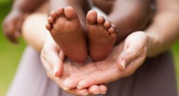 woman holding baby feet