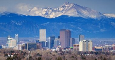 A view of the downtown Denver skyline, which has snow-capped mountains as a backdrop