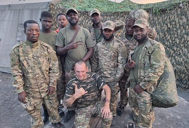 Pictured centre: Ben Stimson, 50, the Oldham antiques dealer and proud socialist who boasts of feeding desperate African fighters into Vladimir Putin's meat grinder
