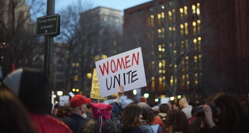“women unite” sign at feminist rally