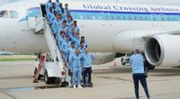 England's players pose on the steps of the plane after touching down in Kansas City