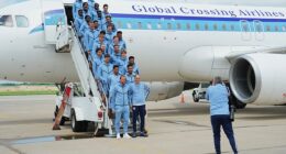 England's players pose on the steps of the plane after touching down in Kansas City