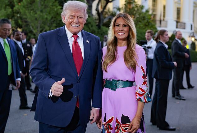 Donald and Melania Trump pose for a photo in front of the White House press photographers during the congressional picnic on the South Lawn of the White House on May 19