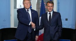 President Donald Trump flashes a frown while offering a contorted handshake to French President Emmanuel Macron