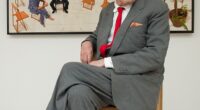 David Hockney, who died aged 88, posing in front of his artwork 'The Chairs'
