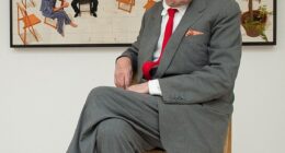 David Hockney, who died aged 88, posing in front of his artwork 'The Chairs'