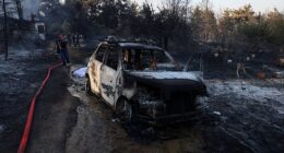 Firefighters try to extinguish a wildfire close to a burnt house and a car near the village of Liti, Thessaloniki, Greece