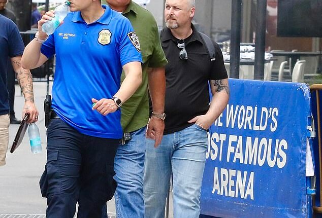 In bombshell new exclusive photographs, Swift's trusted heads of security (middle and right) were pictured outside the iconic venue on Tuesday as preparations for the event ramped up