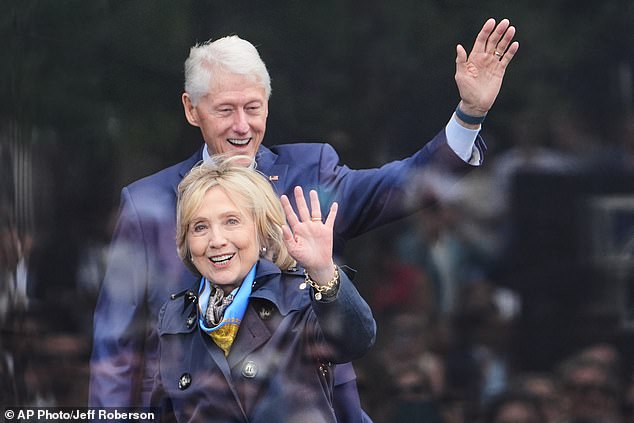 Former President Bill Clinton, behind, and former Secretary of State Hillary Clinton arrive on stage during the dedication ceremony for the Obama Presidential Center, June 18