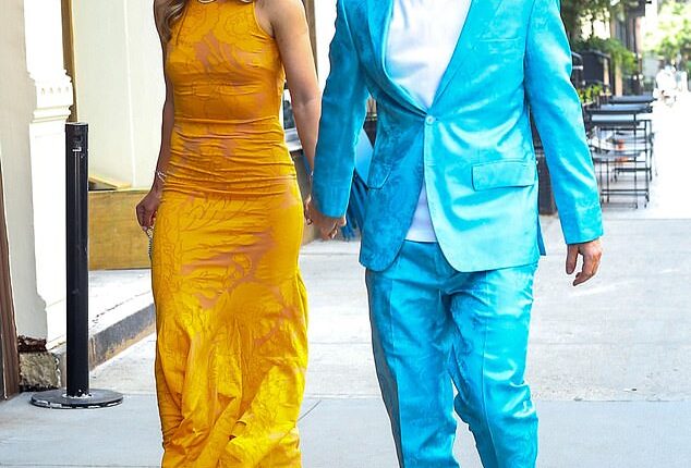 Clashing colors! Singer Ed Sheeran stood out from the crowd as he sported a bright turquoise silk suit with a paisley pattern on it. Underneath, he wore a white t-shirt, and accessorized with a pair of black Nike sneakers complete with a matching turquoise 'swoosh' on the side. His wife, Cherry Seaborn, wore a bright yellow, silky, curve-hugging gown that also appeared to have a paisley pattern on it. She paired the high-neck dress with bedazzled sky-high heels, a diamond necklace, and dangling diamond earrings